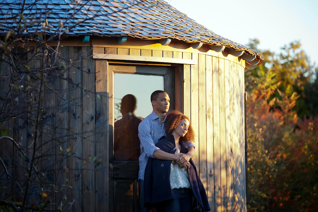 Couple debout par la yourte pendant le coucher du soleil